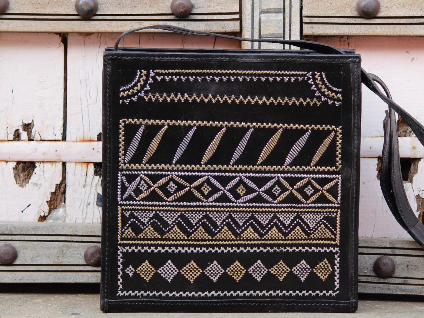 Black leather bag adorned with intricate zari work on premium handcrafted leather