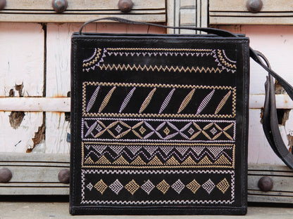 Black leather bag adorned with intricate zari work on premium handcrafted leather