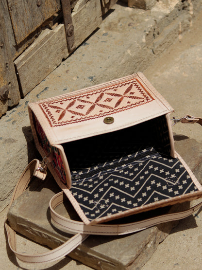 Leather hut bag adorned with intricate handcrafted thread work and traditional detailing