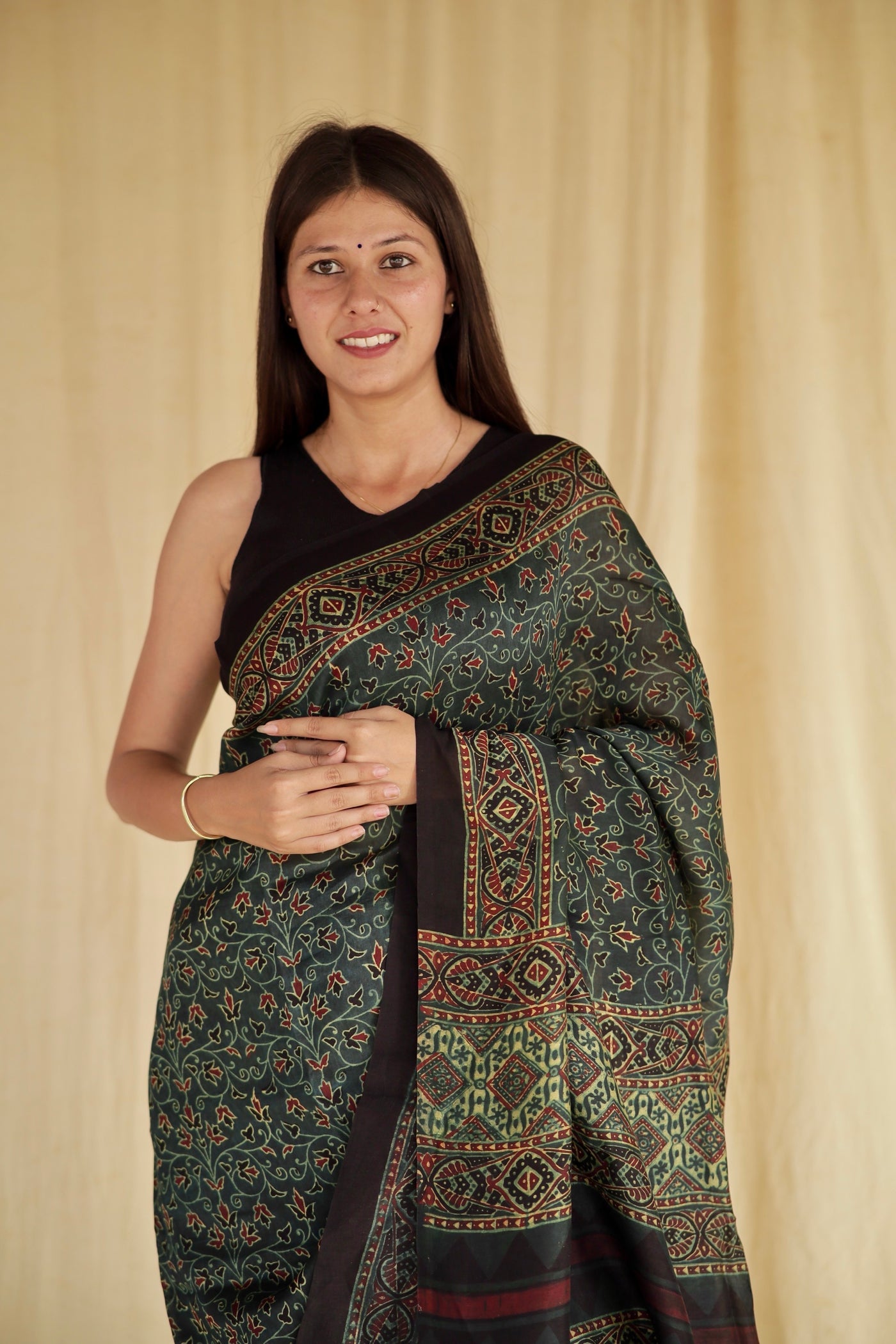 Handcrafted bottle green modal silk saree adorned with traditional Ajrakh patterns and soft texture
