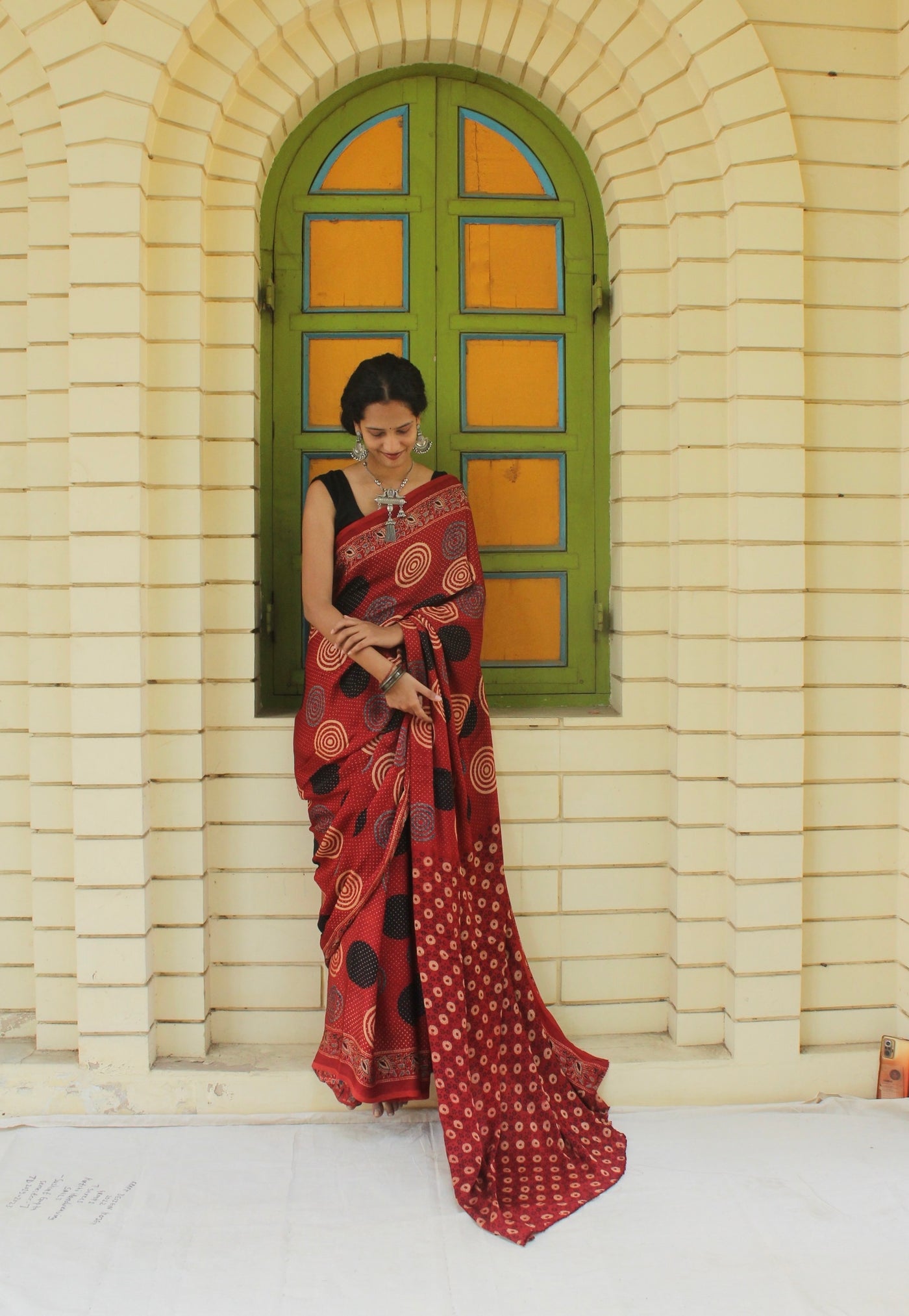 Handcrafted brick red modal silk saree adorned with traditional Ajrakh patterns and rich detailing