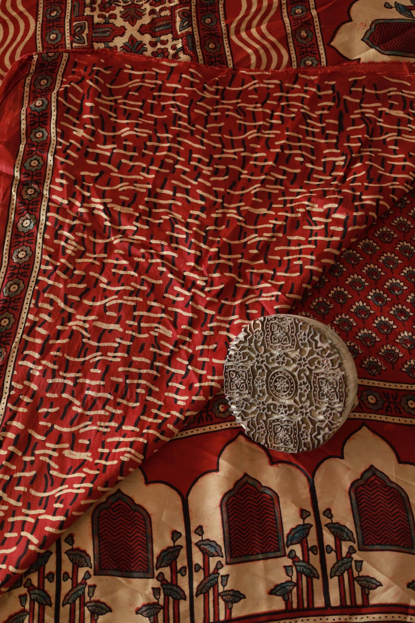 Handcrafted burgundy modal silk saree adorned with traditional Ajrakh patterns and artisanal detailing