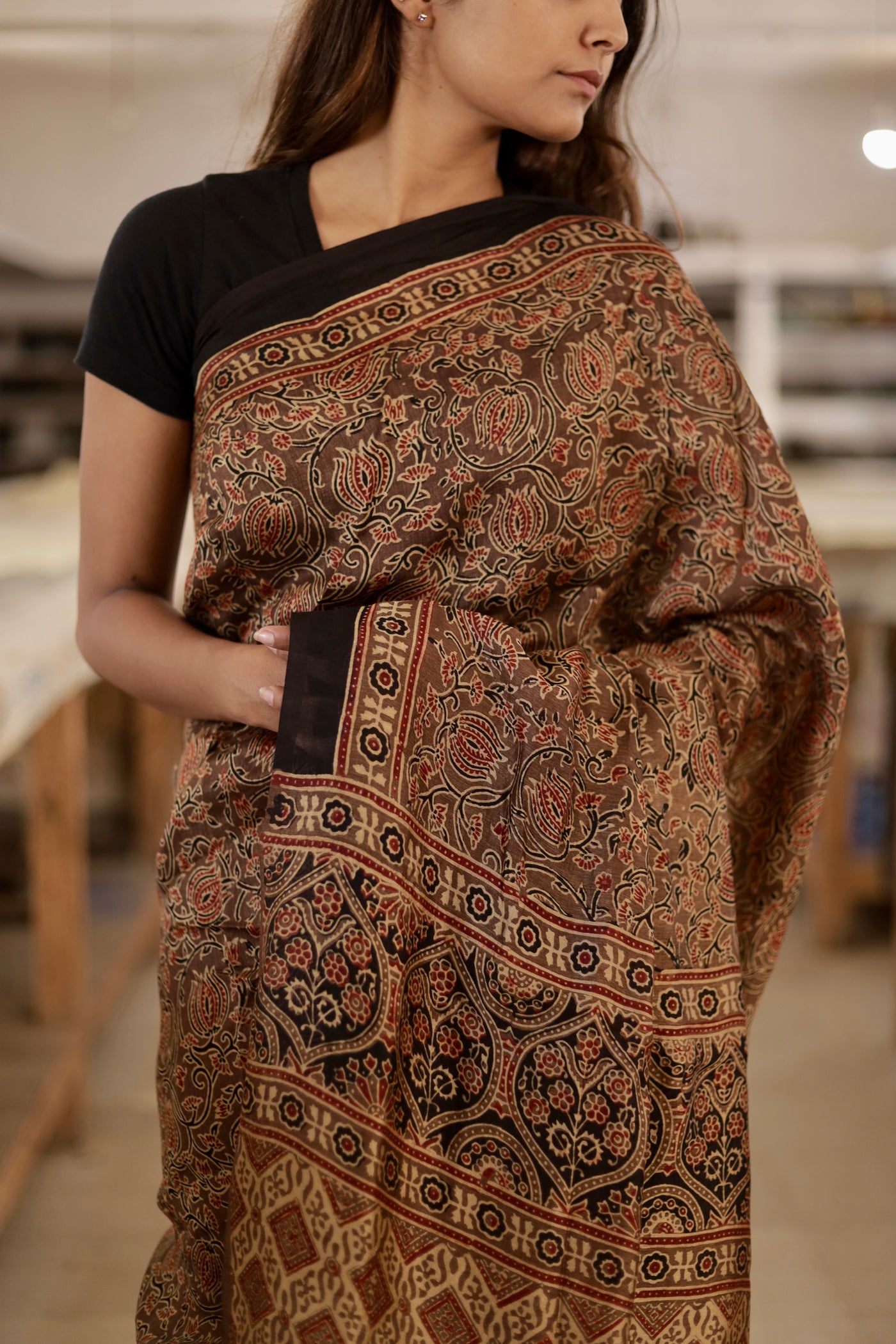 Handcrafted caramel brown modal silk saree adorned with traditional Ajrakh patterns and artisanal detailing
