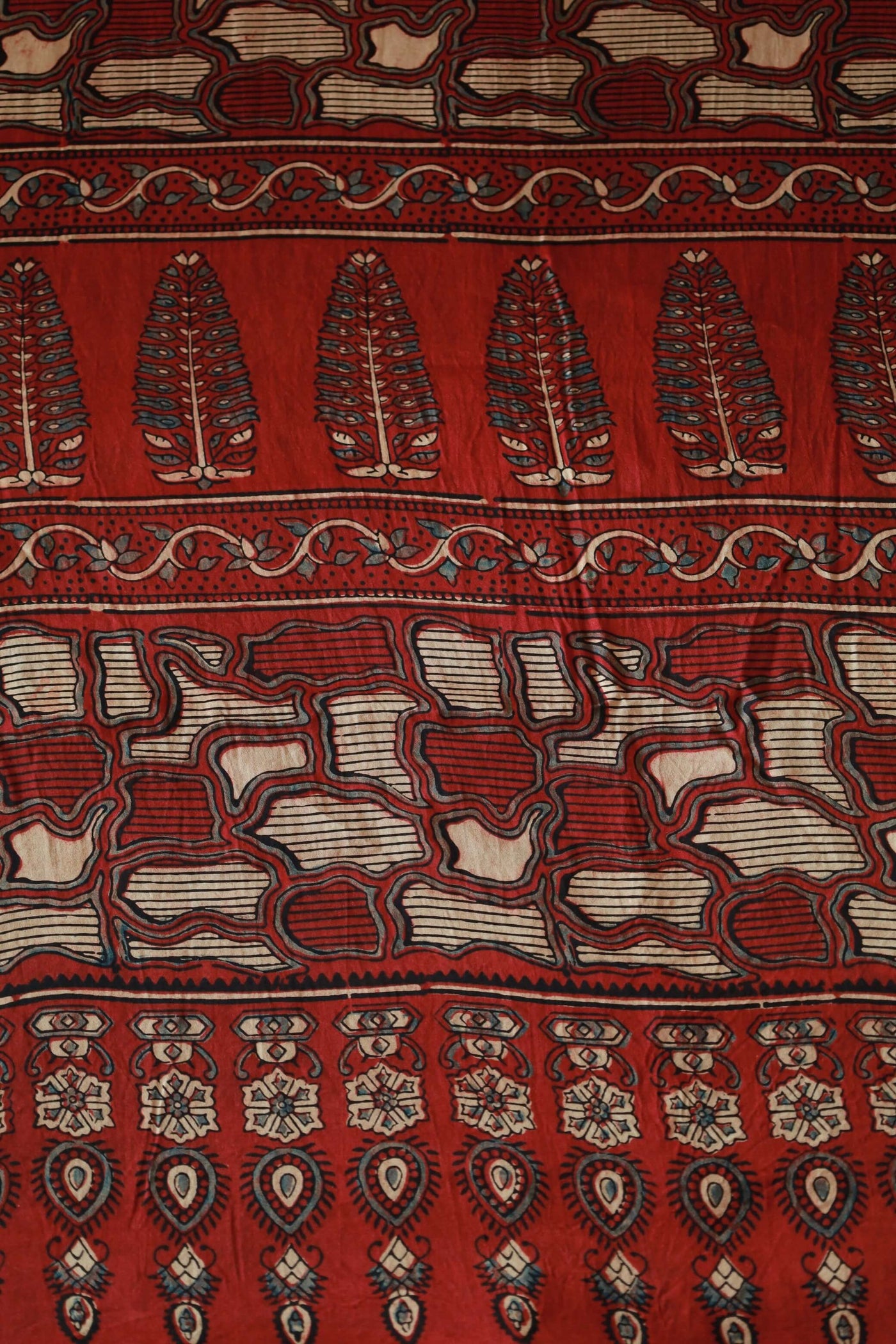 Handcrafted crimson red modal silk saree adorned with traditional Ajrakh patterns and artisanal detailing