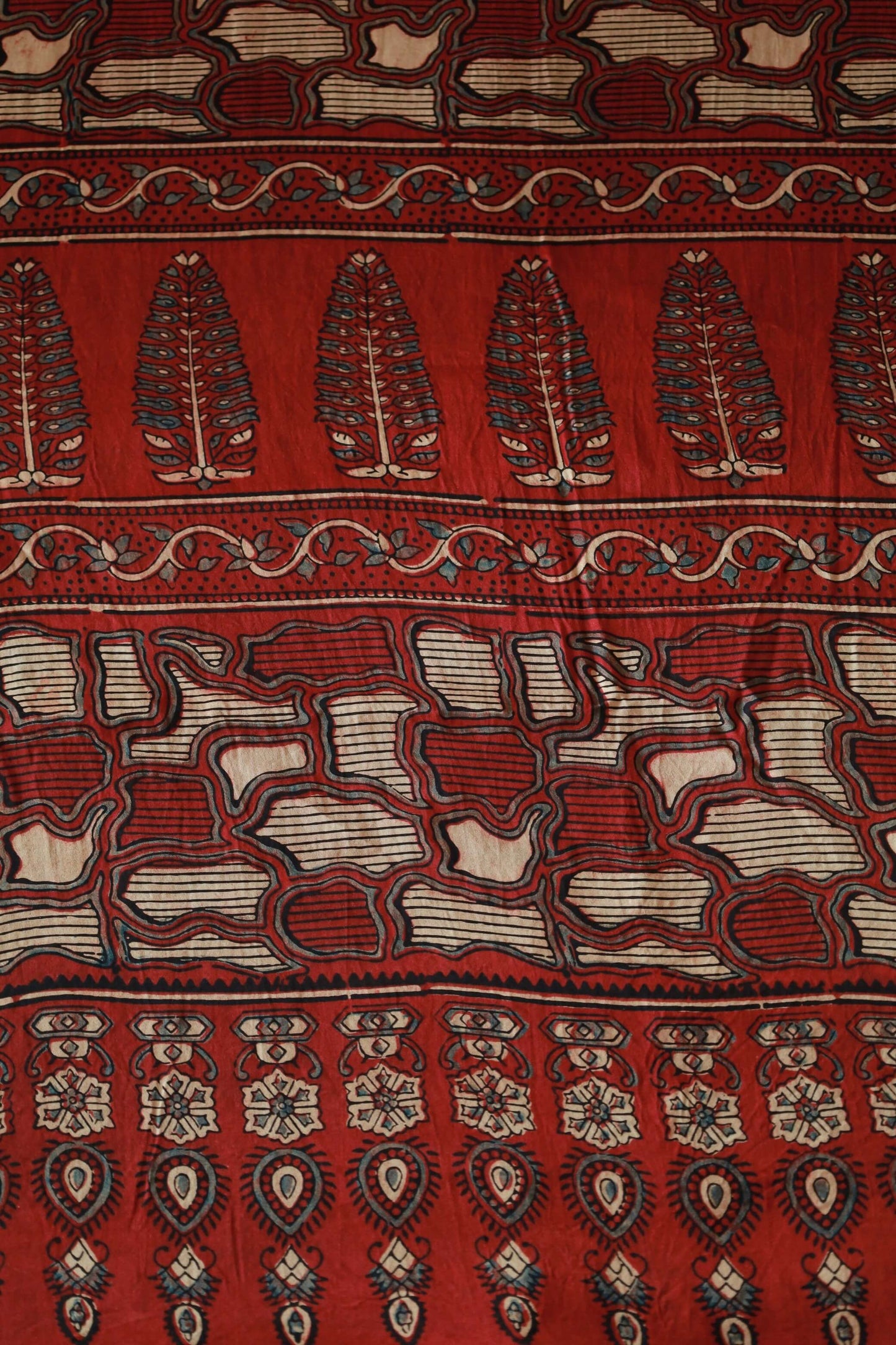 Handcrafted crimson red modal silk saree adorned with traditional Ajrakh patterns and artisanal detailing