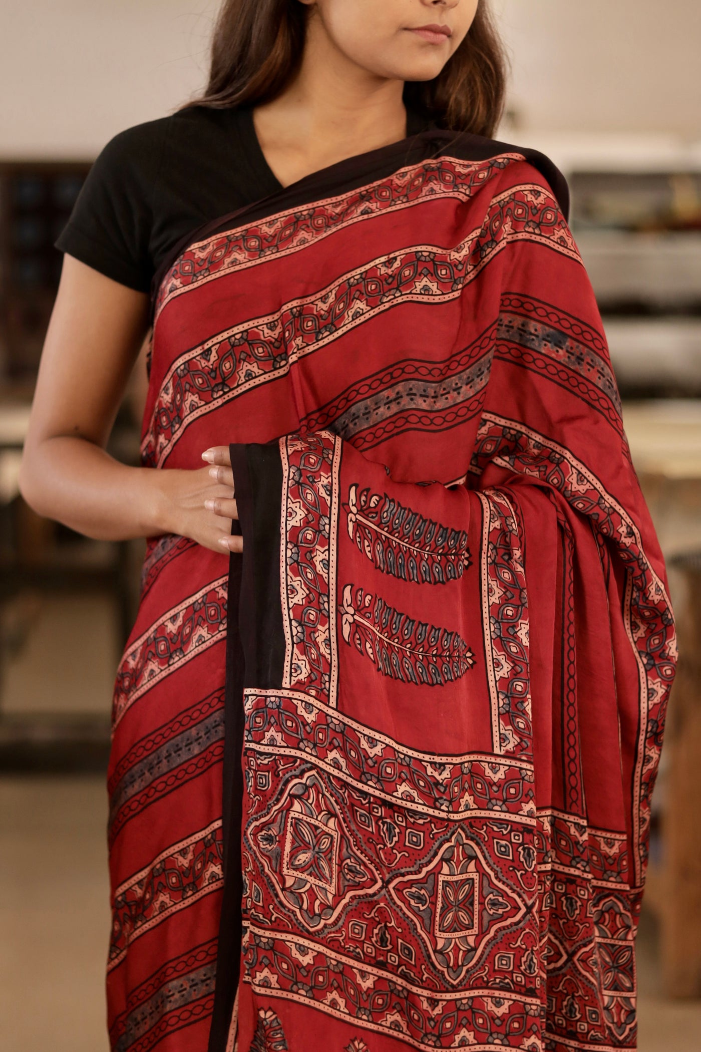 Handcrafted deep garnet modal silk saree adorned with traditional Ajrakh patterns and artisanal detailing