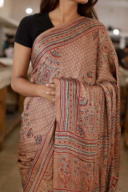 Handcrafted dusty brown modal silk saree adorned with traditional Ajrakh patterns and shimmering zari detailing