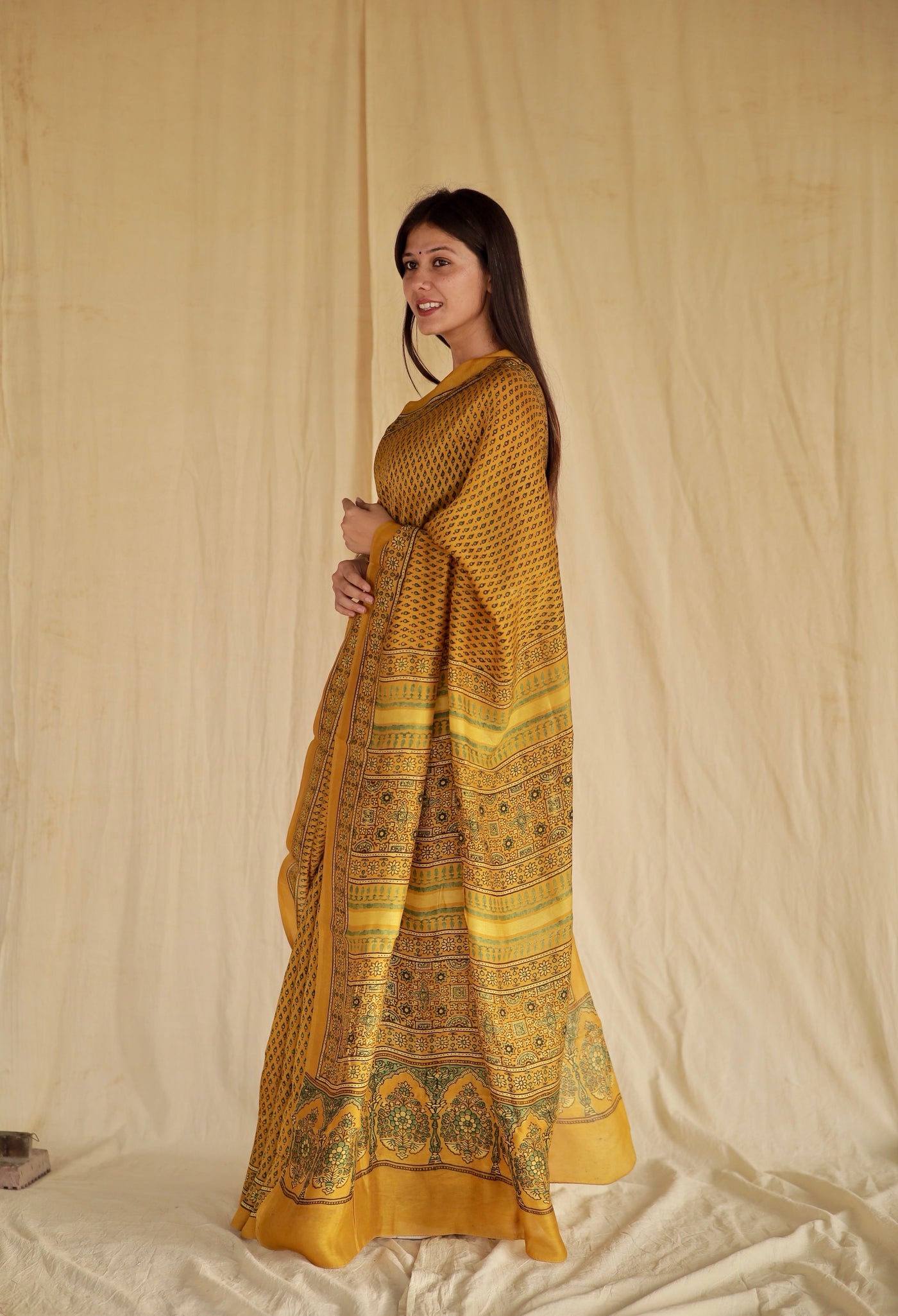 Golden mustard Ajrakh Chanderi silk saree featuring intricate hand block printed motifs and a graceful drape
