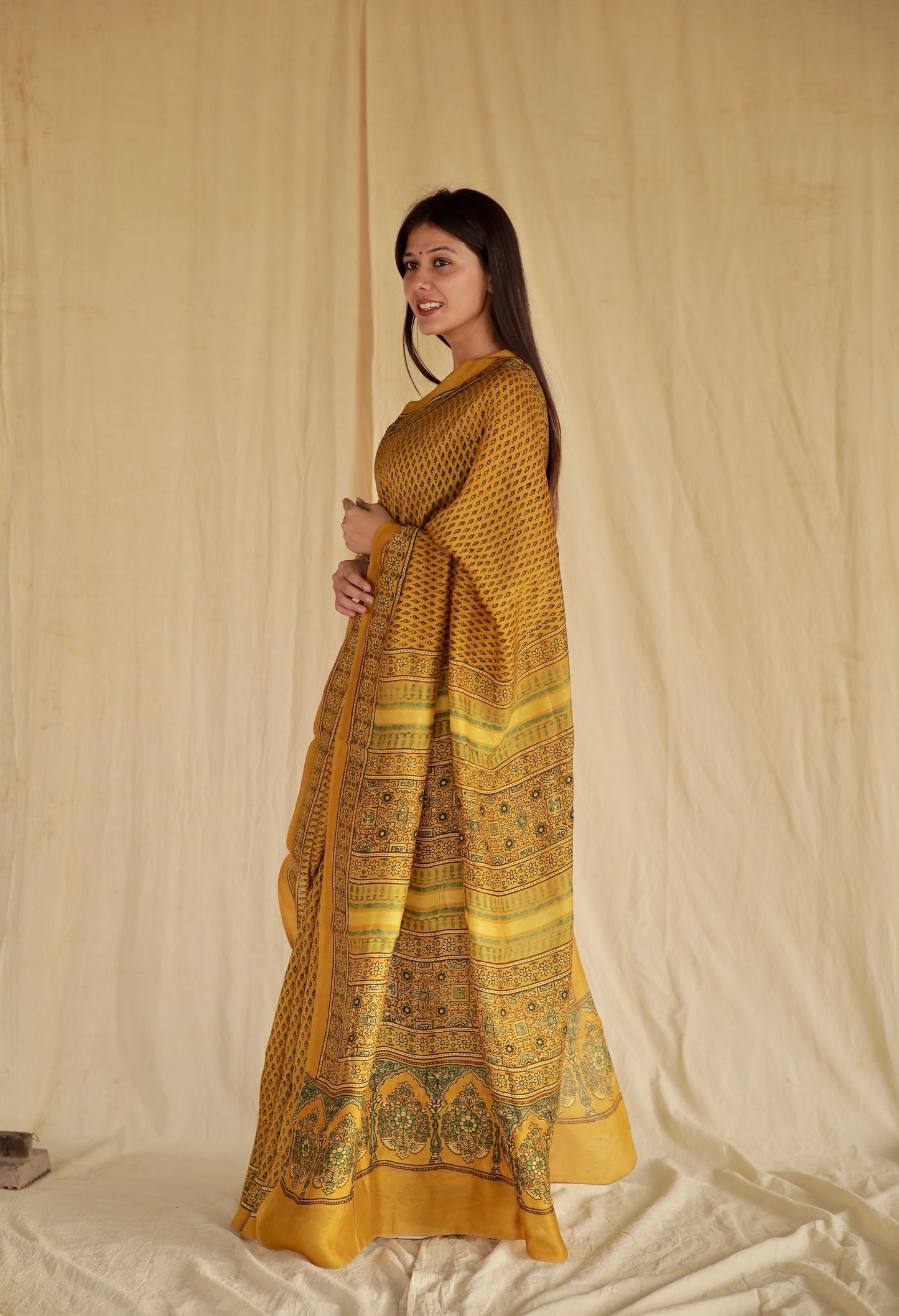Golden mustard Ajrakh Chanderi silk saree featuring intricate hand block printed motifs and a graceful drape