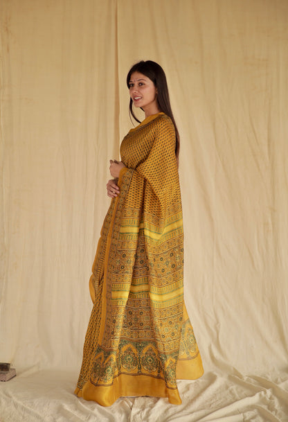 Golden mustard Ajrakh Chanderi silk saree featuring intricate hand block printed motifs and a graceful drape