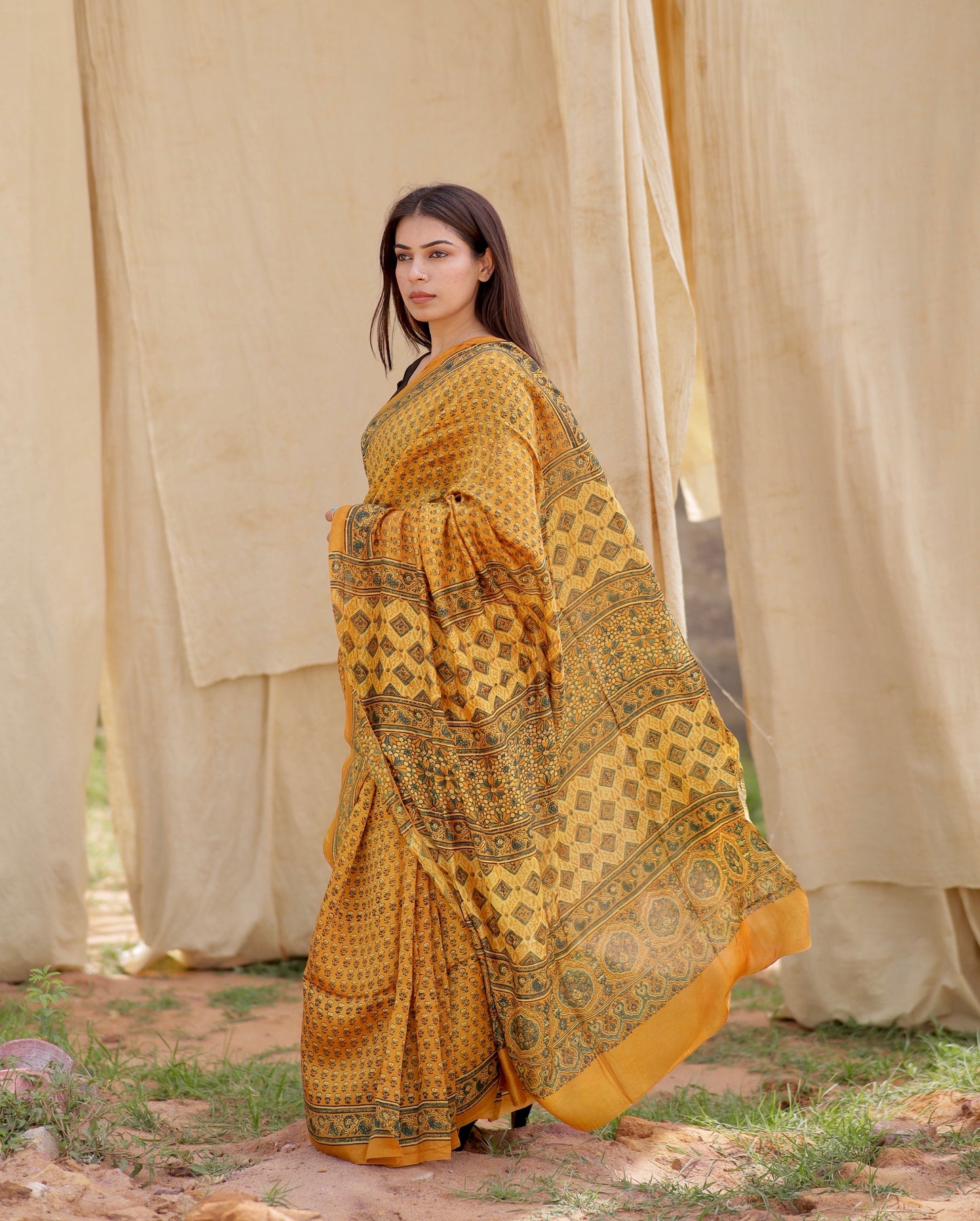 Handcrafted mustard yellow Chanderi silk saree adorned with traditional Ajrakh patterns and delicate texture