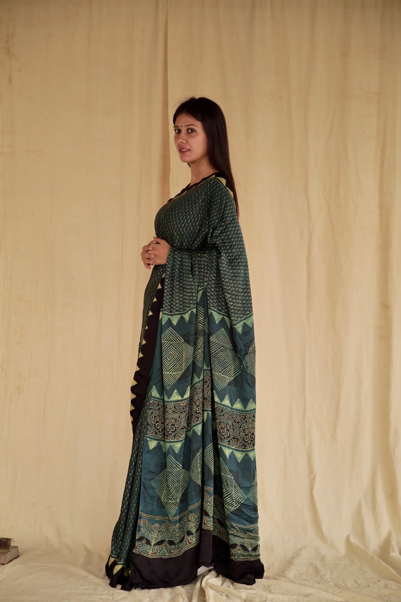 Handcrafted pine green modal silk saree adorned with intricate Ajrakh patterns inspired by heritage craftsmanship