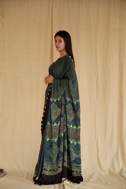 Handcrafted pine green modal silk saree adorned with intricate Ajrakh patterns inspired by heritage craftsmanship