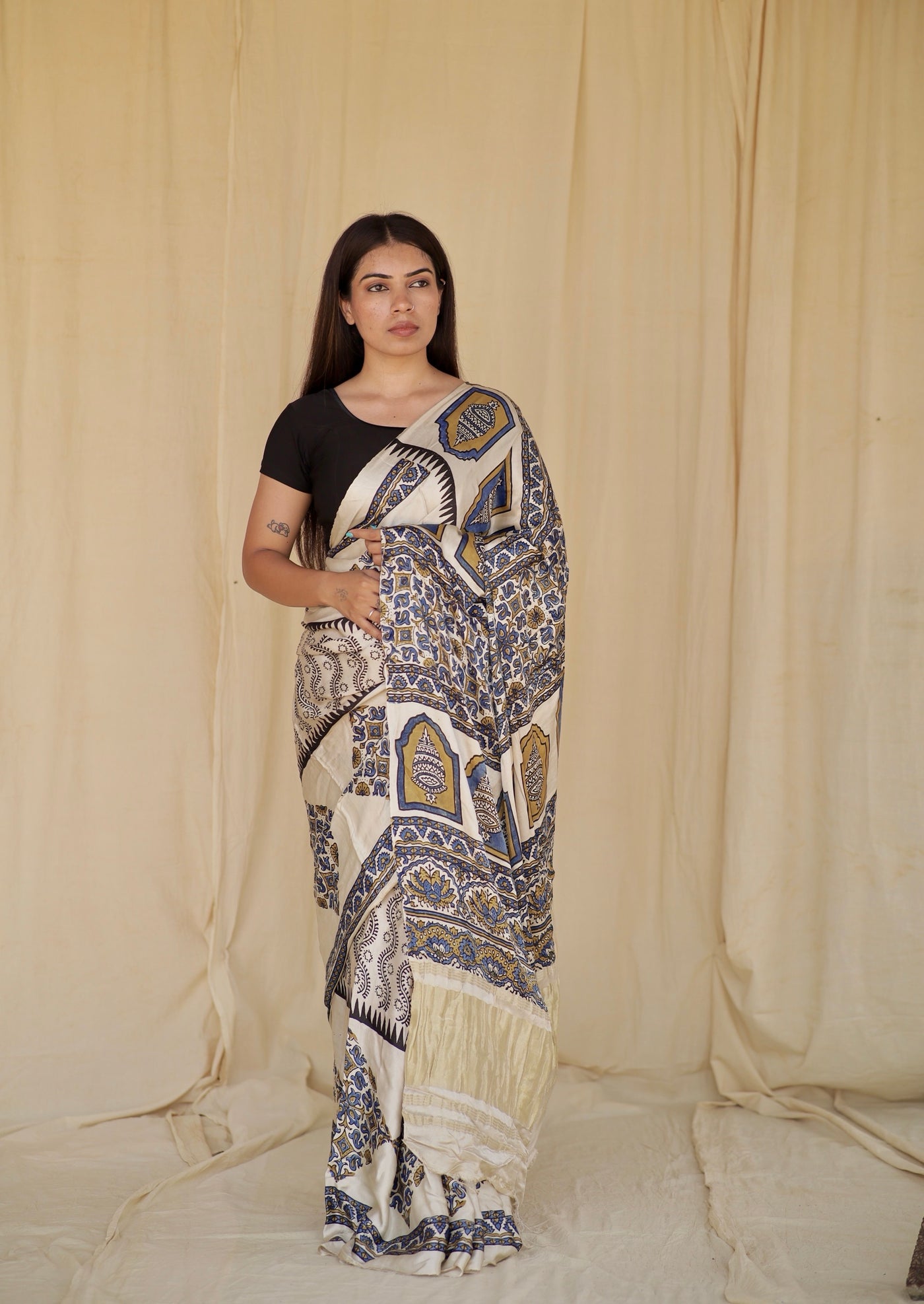Ivory white Ajrakh modal silk saree featuring intricate hand block printed motifs and a graceful drape