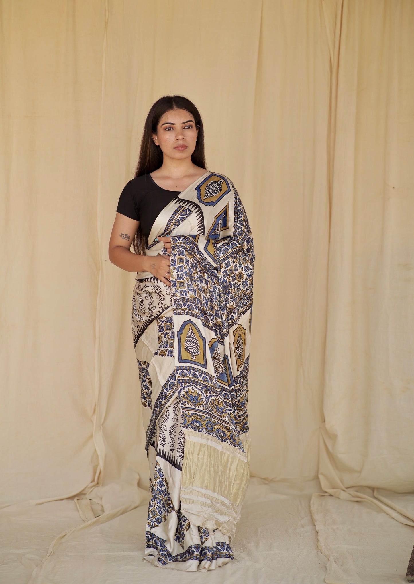 Ivory white Ajrakh modal silk saree featuring intricate hand block printed motifs and a graceful drape