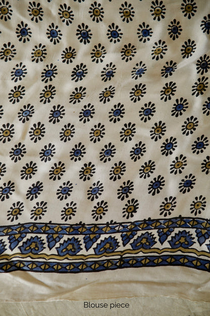 Ivory white modal silk saree with heritage-inspired Ajrakh designs and a soft flowing texture. Traditional ivory white Ajrakh printed modal silk saree crafted by artisans with refined craftsmanship