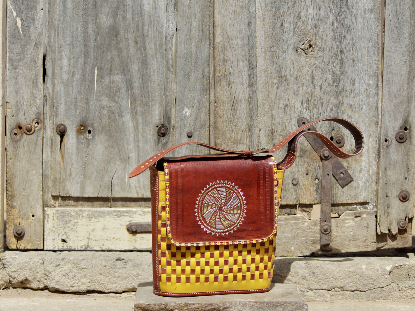 Premium leather bag combining durable leather construction with decorative zari work