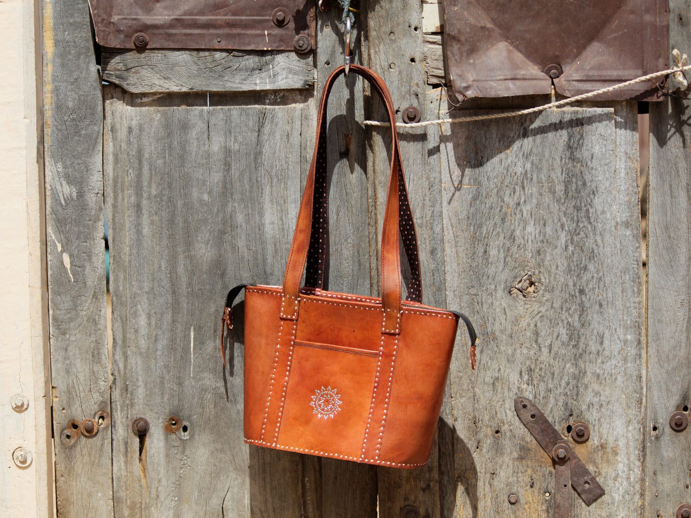 Leather bag adorned with intricate zari work on premium handcrafted leather
