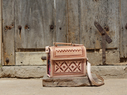Leather hut bag adorned with intricate handcrafted thread work and traditional detailing