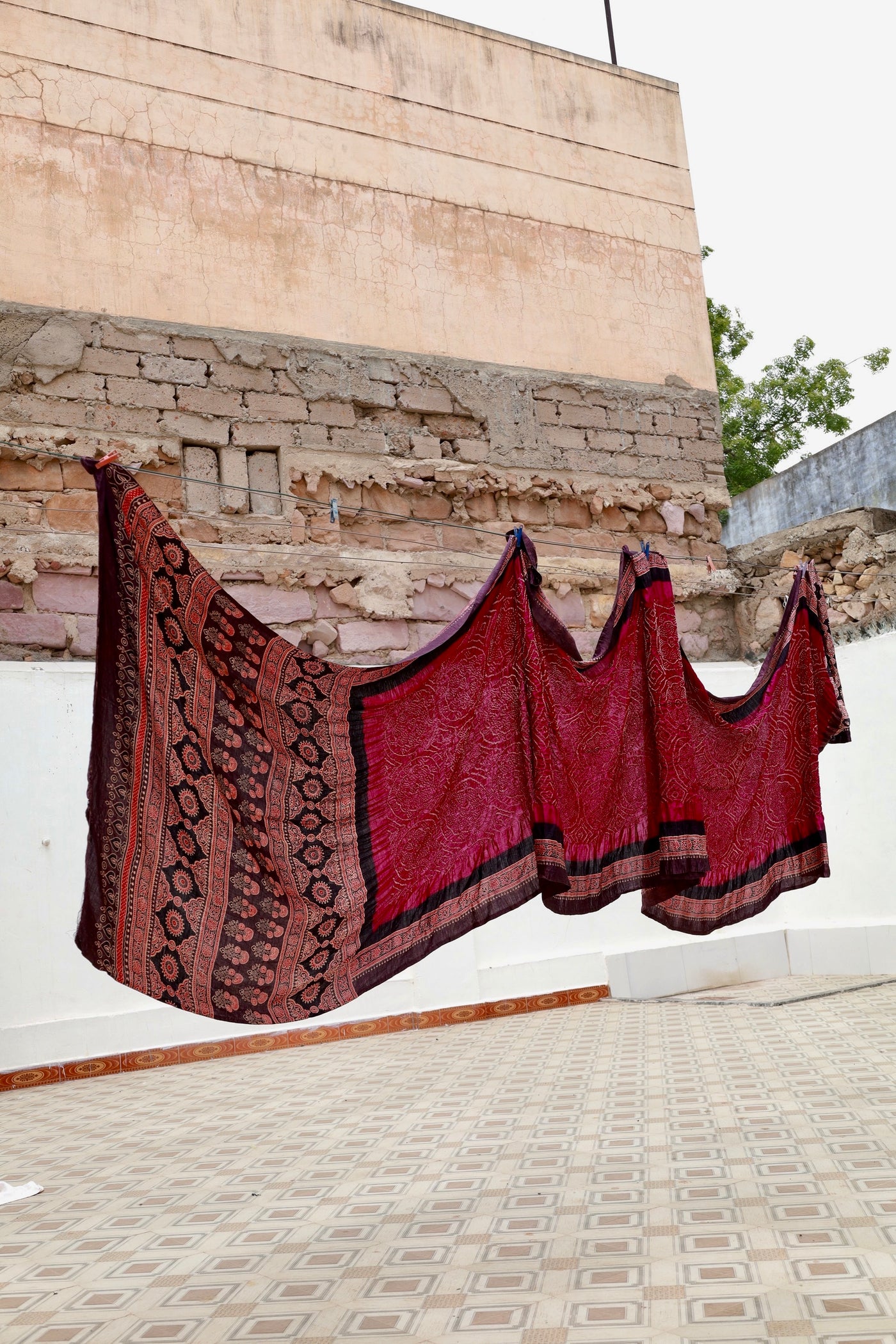 Maroon Ajrakh Bandhani silk saree featuring intricate block-printed motifs and traditional tie-dye patterns