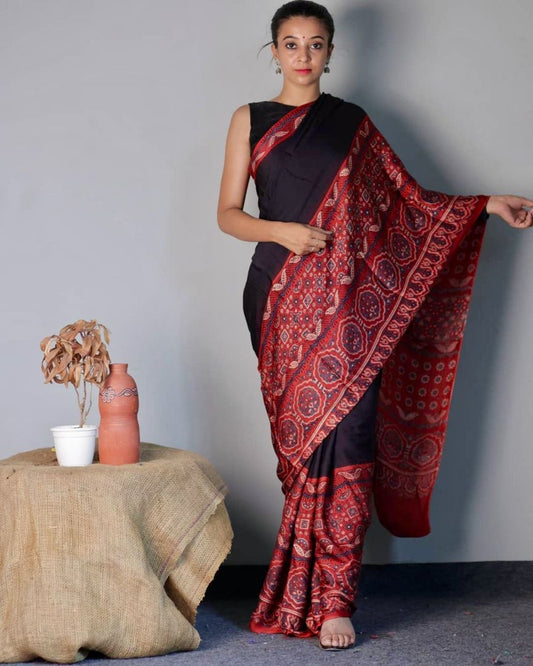 Midnight black and red Ajrakh modal silk saree featuring intricate hand block printed motifs and a graceful drape