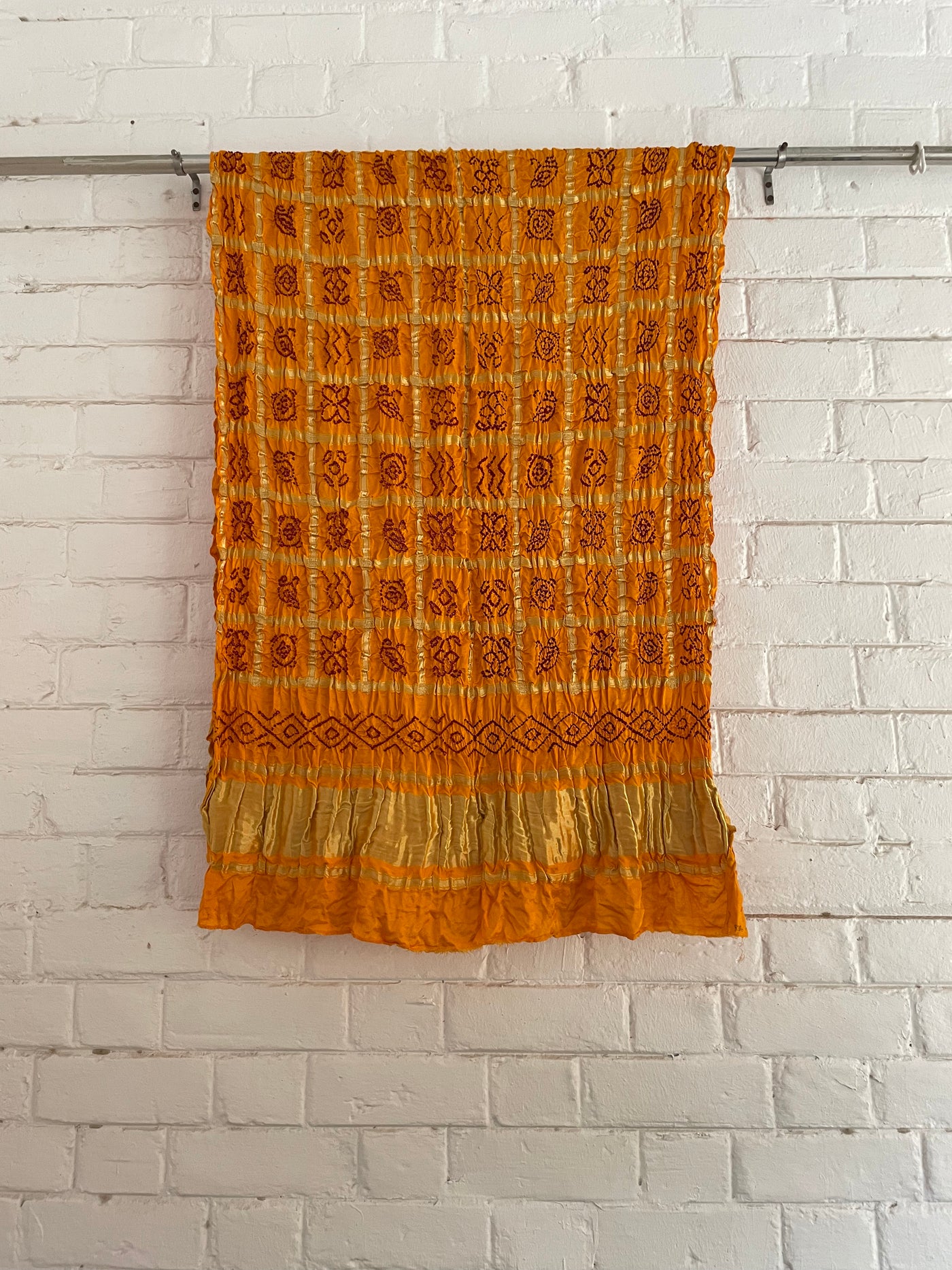 Ethnic mustard yellow Gharchola dupatta showcasing fine Bandhani artistry and woven zari accents