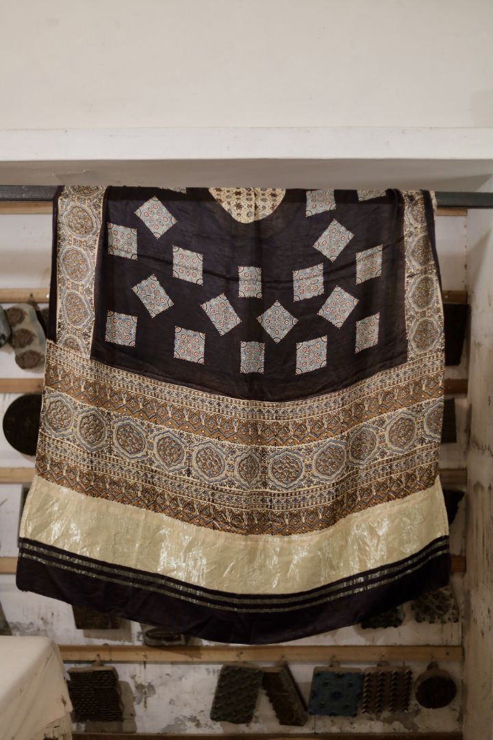 Natural black Ajrakh modal silk dupatta with Lagdi Patta featuring intricate block printed motifs and elegant drape