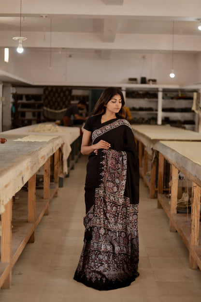 Plain black Ajrakh modal silk saree featuring subtle handcrafted detailing and an elegant drape