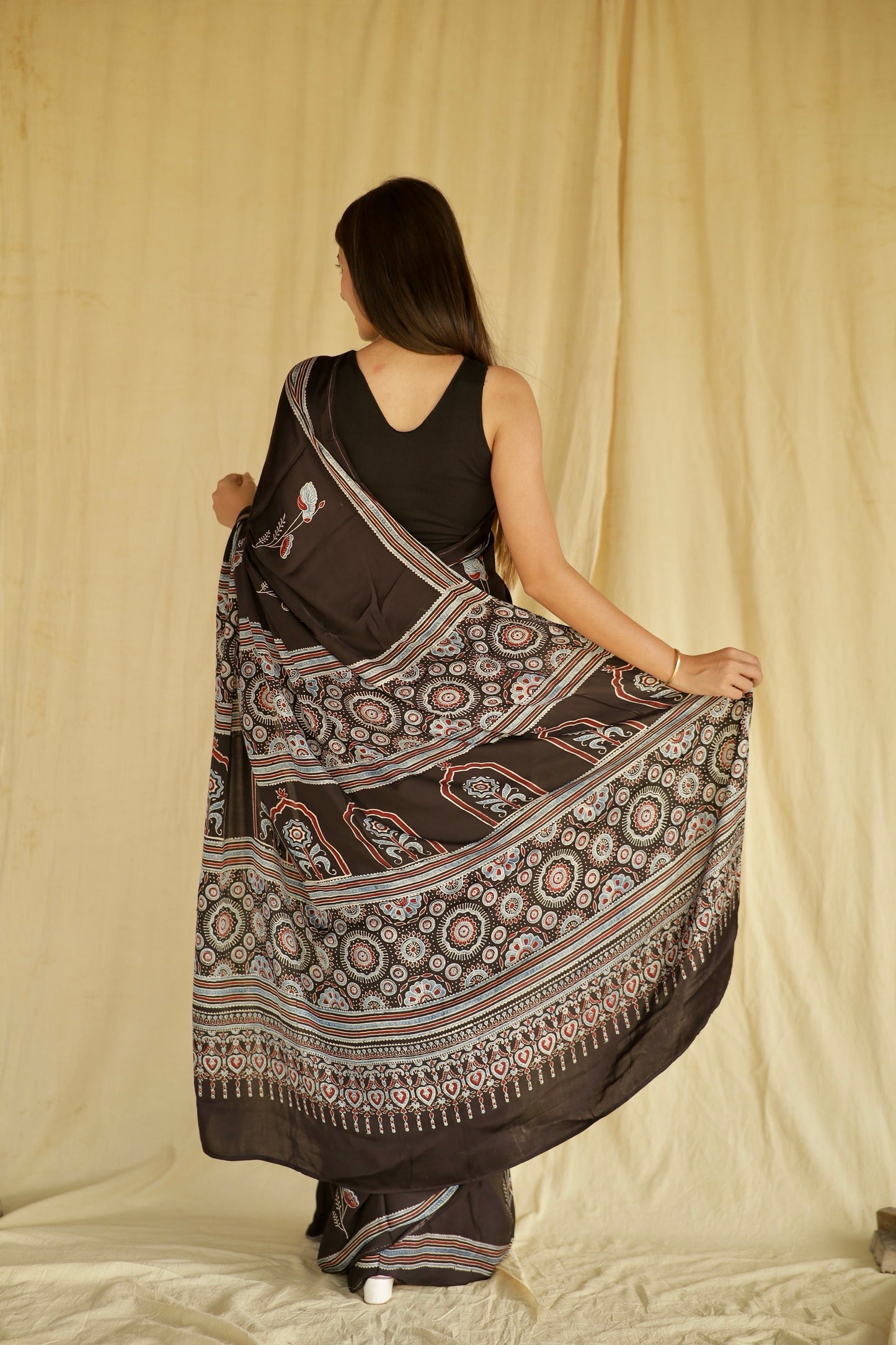 Traditional charcoal black Ajrakh printed modal silk saree crafted by skilled artisans with refined detailing