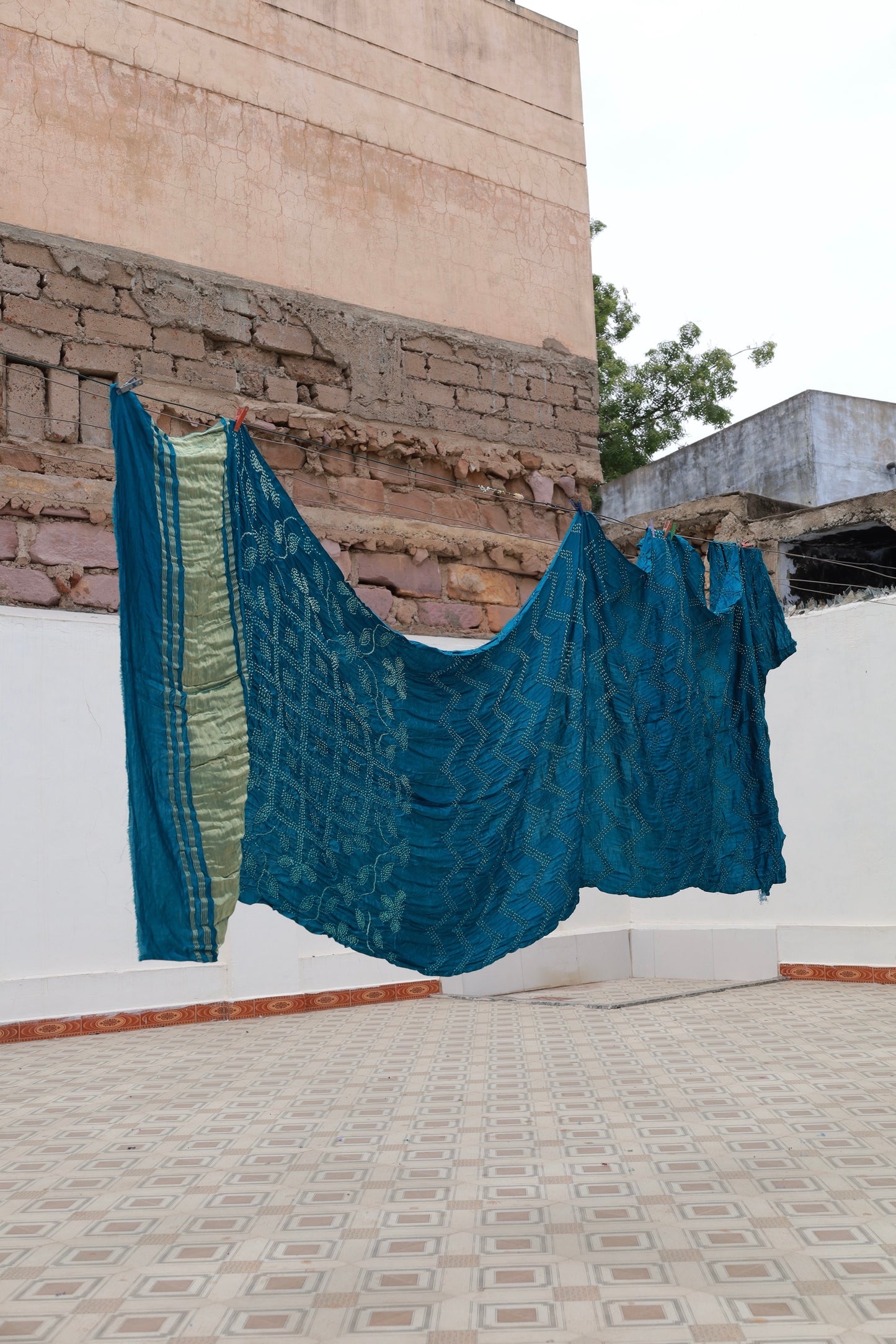 Deep sea Rai Bandhani silk saree featuring intricate tie-dye patterns and an elegant zari pallu