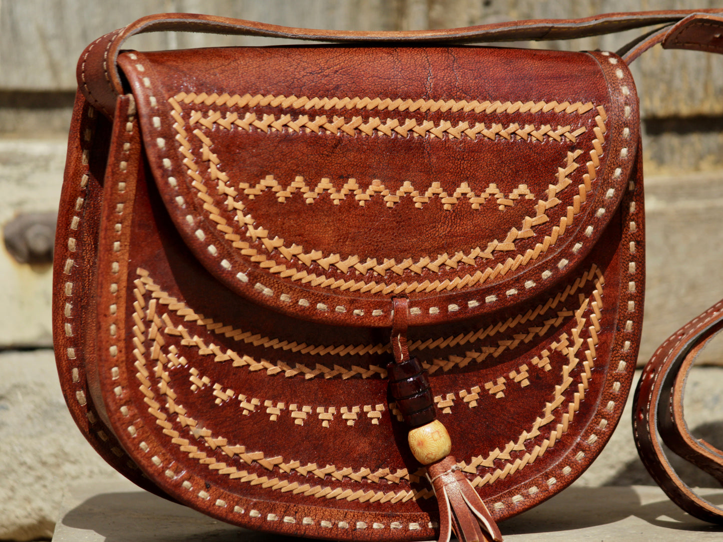 Leather bag adorned with intricate thread work on premium handcrafted leather