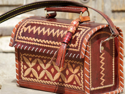 Premium leather hut bag combining skilled leatherwork with artistic thread detailing