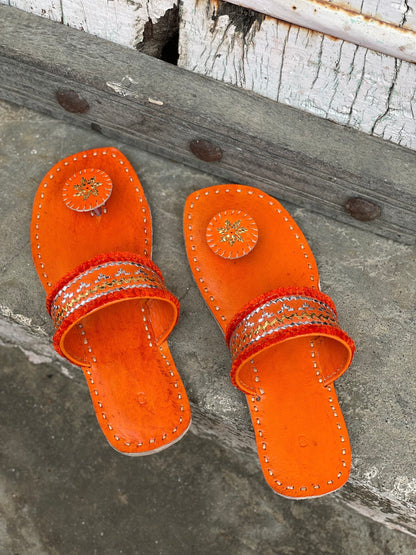 Orange handstitched leather flats showcasing traditional craftsmanship and comfortable design
