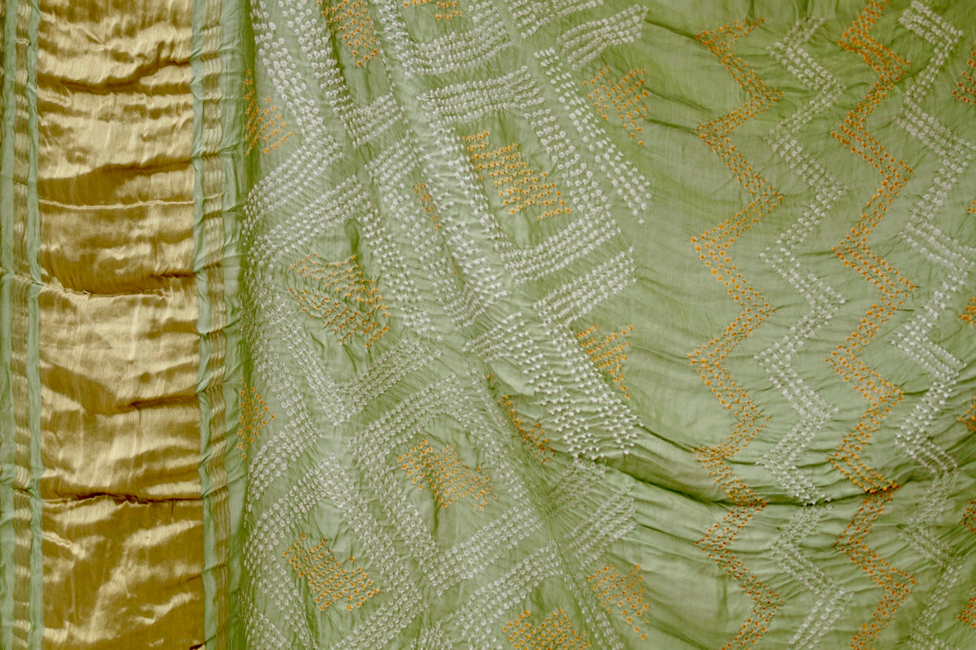 Handcrafted sage green silk saree showcasing authentic Rai Bandhani artistry with rich zari detailing