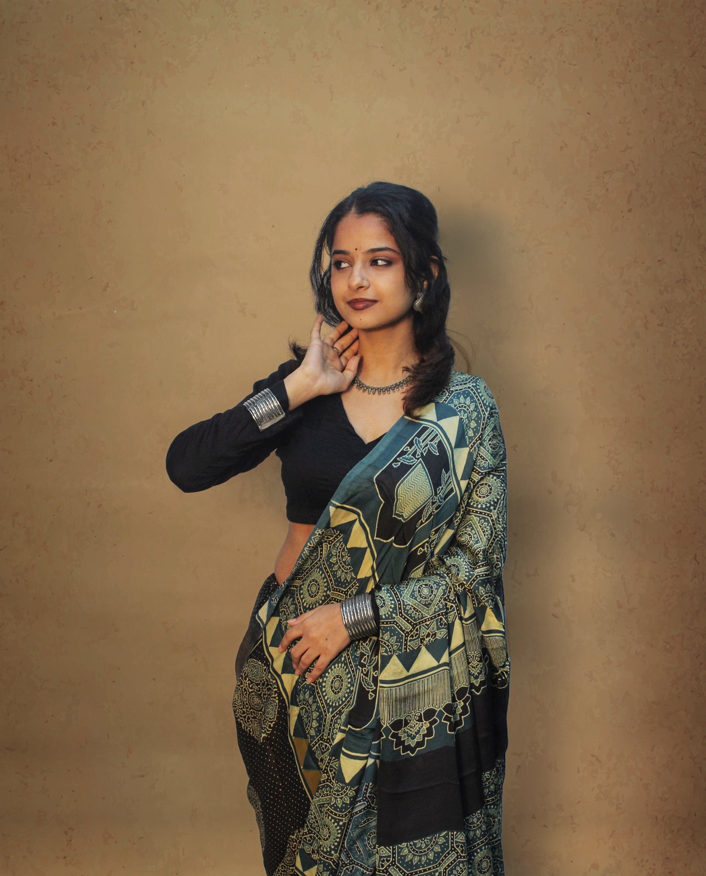 Traditional teal blue Ajrakh printed modal silk saree crafted by skilled artisans with refined craftsmanship