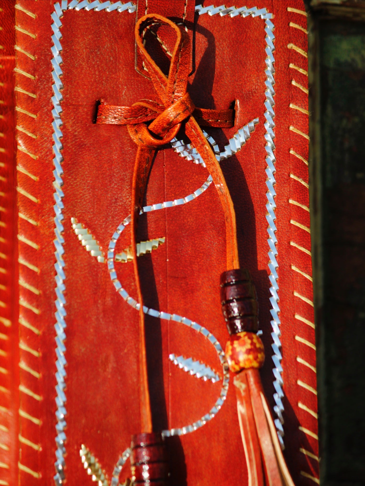 Premium leather potli bag combining durable leather construction with heritage zari artistry