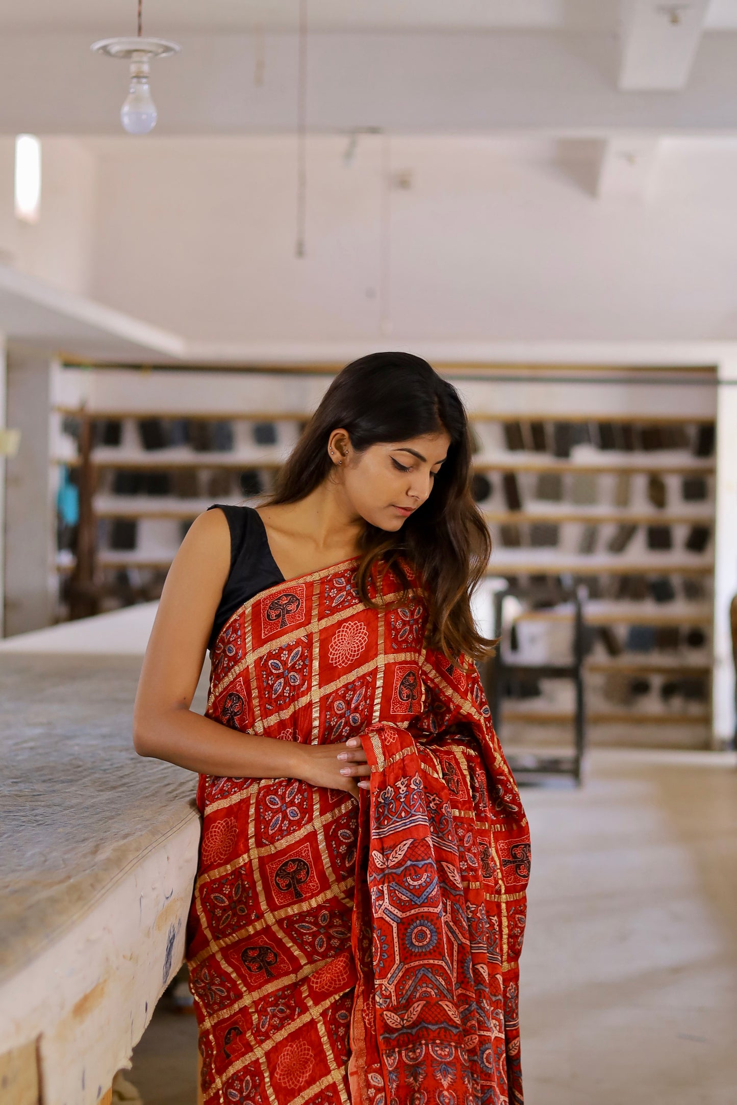 Red Gharchola Ajrakh modal silk saree featuring traditional motifs and a graceful drape