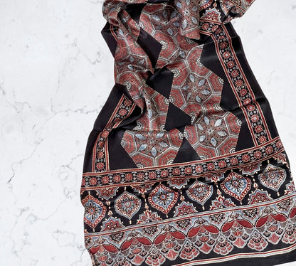 Rust black Ajrakh modal silk stole featuring intricate hand block printed motifs and elegant drape