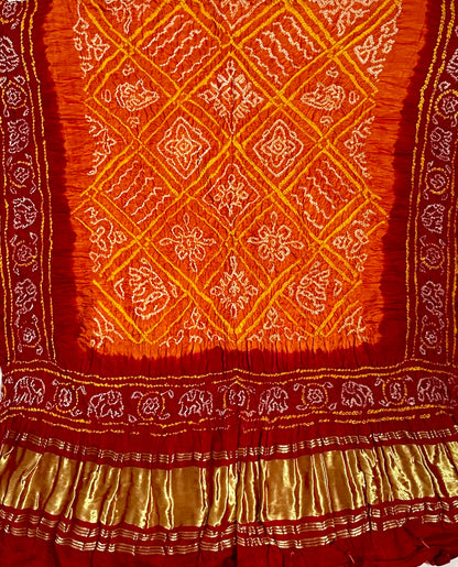 Saffron orange and red Bandhani Gajji silk dupatta featuring traditional tie-dye craftsmanship and elegant drape