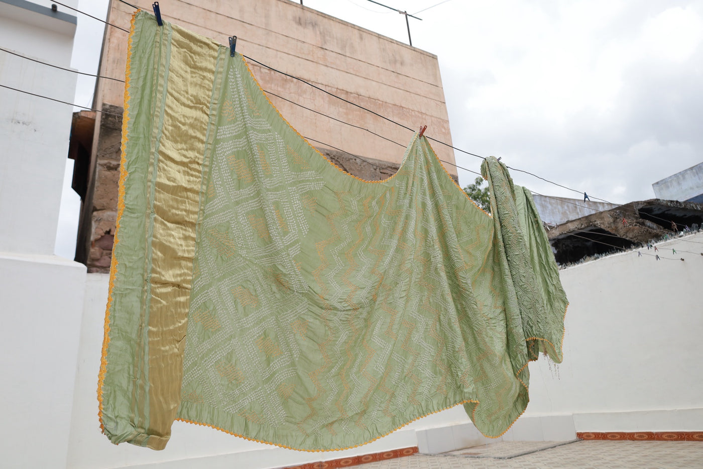 Sage green Rai Bandhani silk saree featuring intricate tie-dye patterns and an elegant zari pallu