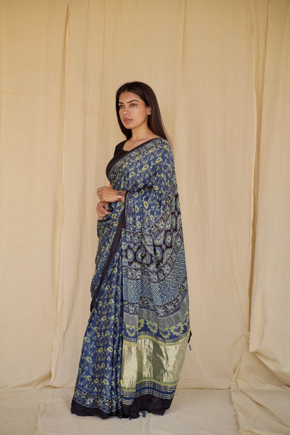 Steel blue Ajrakh modal silk saree featuring intricate hand block printed motifs and a graceful drape