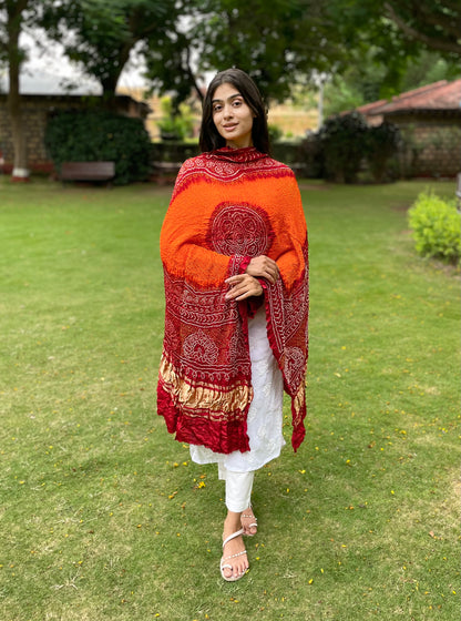 Tangerine and red Bandhani Gajji silk dupatta with traditional tie-dye patterns and elegant drape