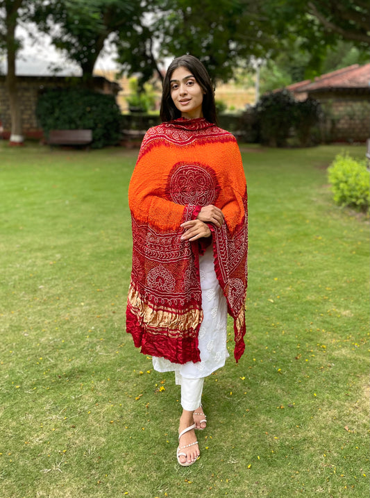 Tangerine and red Bandhani Gajji silk dupatta with traditional tie-dye patterns and elegant drape
