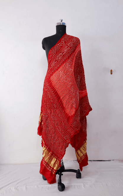 Tomato red and orange Gajji silk Rai Bandhej dupatta featuring intricate tie-dye craftsmanship and elegant drape