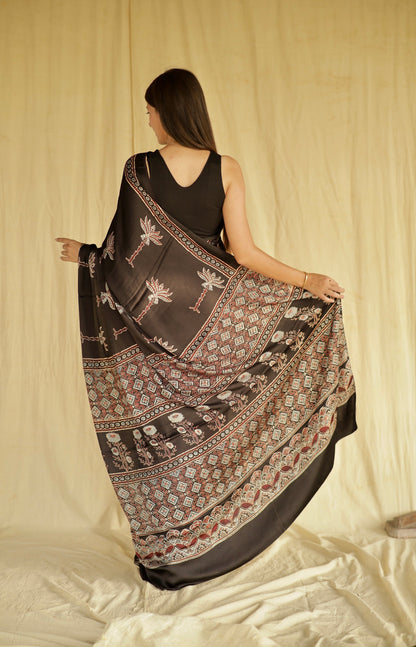 Premium black Ajrakh modal silk saree with lotus-inspired motifs and heritage craftsmanship