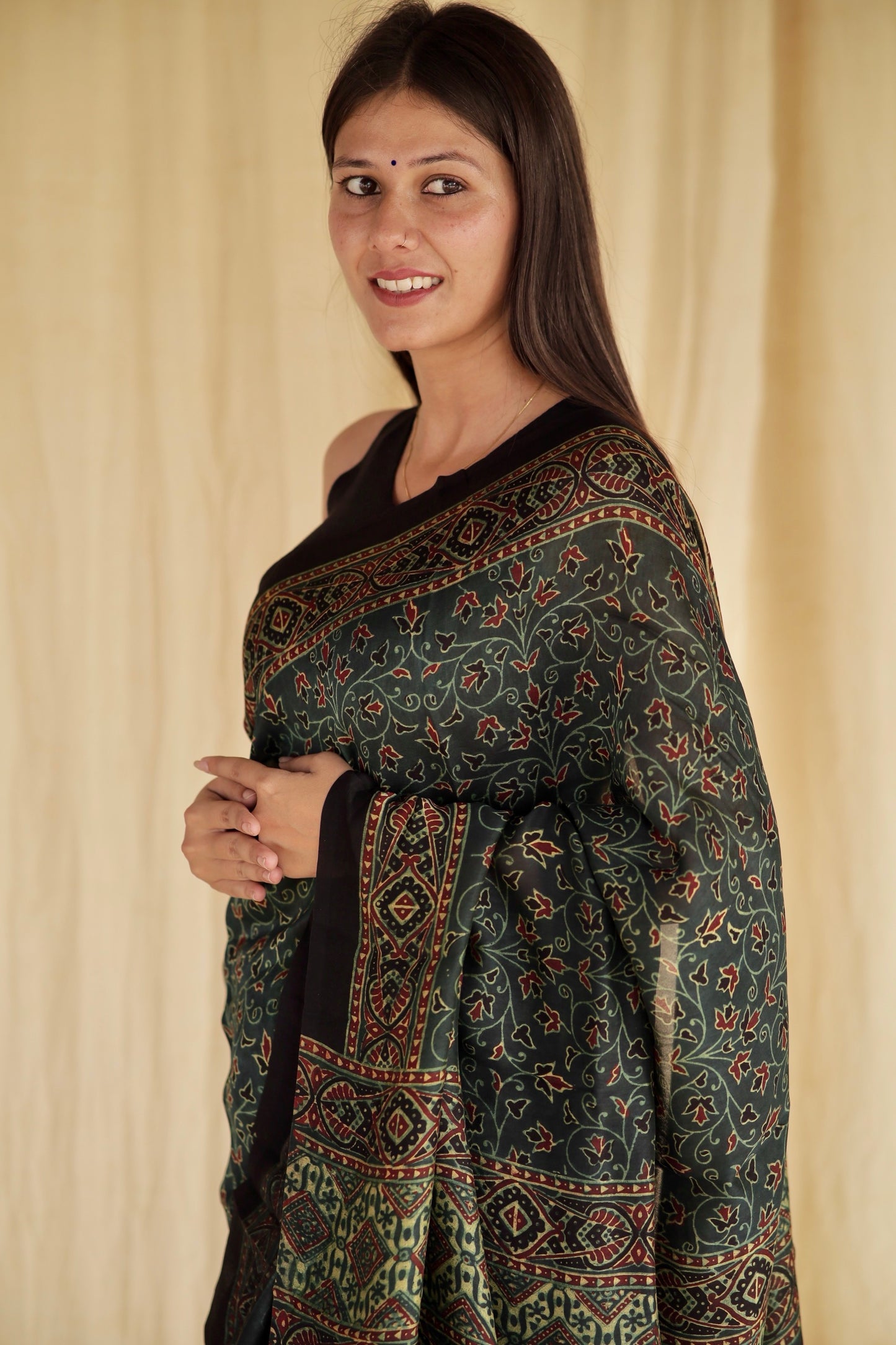 Premium bottle green modal silk saree with heritage-inspired Ajrakh designs and graceful fall