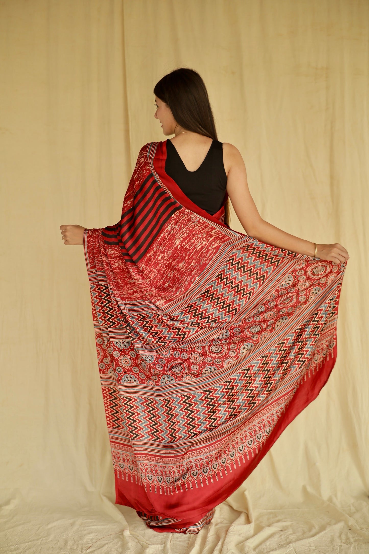 Premium cherry red modal silk saree with heritage-inspired Ajrakh designs and fluid texture