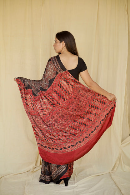 Premium dark mocha modal silk saree with heritage-inspired Ajrakh designs and fluid texture