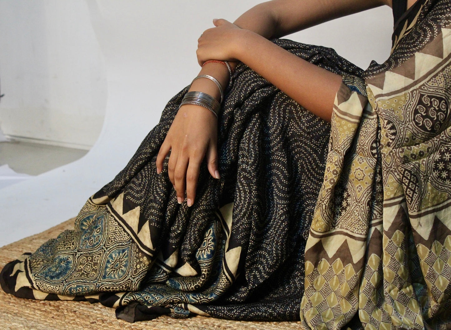 Premium espresso brown modal silk saree with heritage-inspired Ajrakh designs and fluid texture