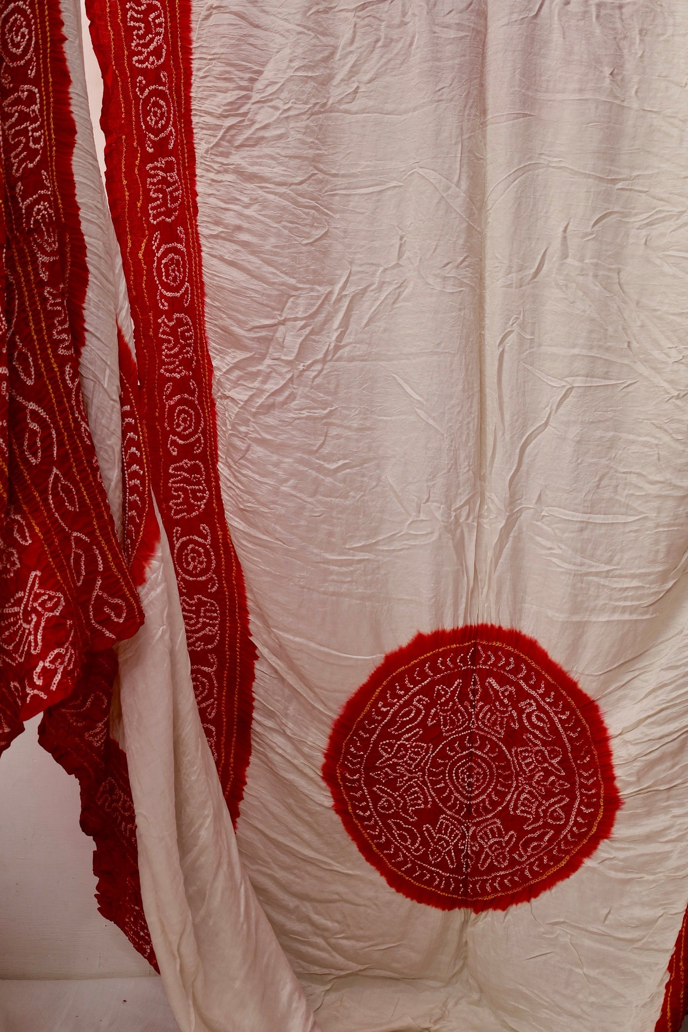 Handcrafted ivory red Gajji silk saree showcasing authentic Bandhani artistry with rich zari detailing